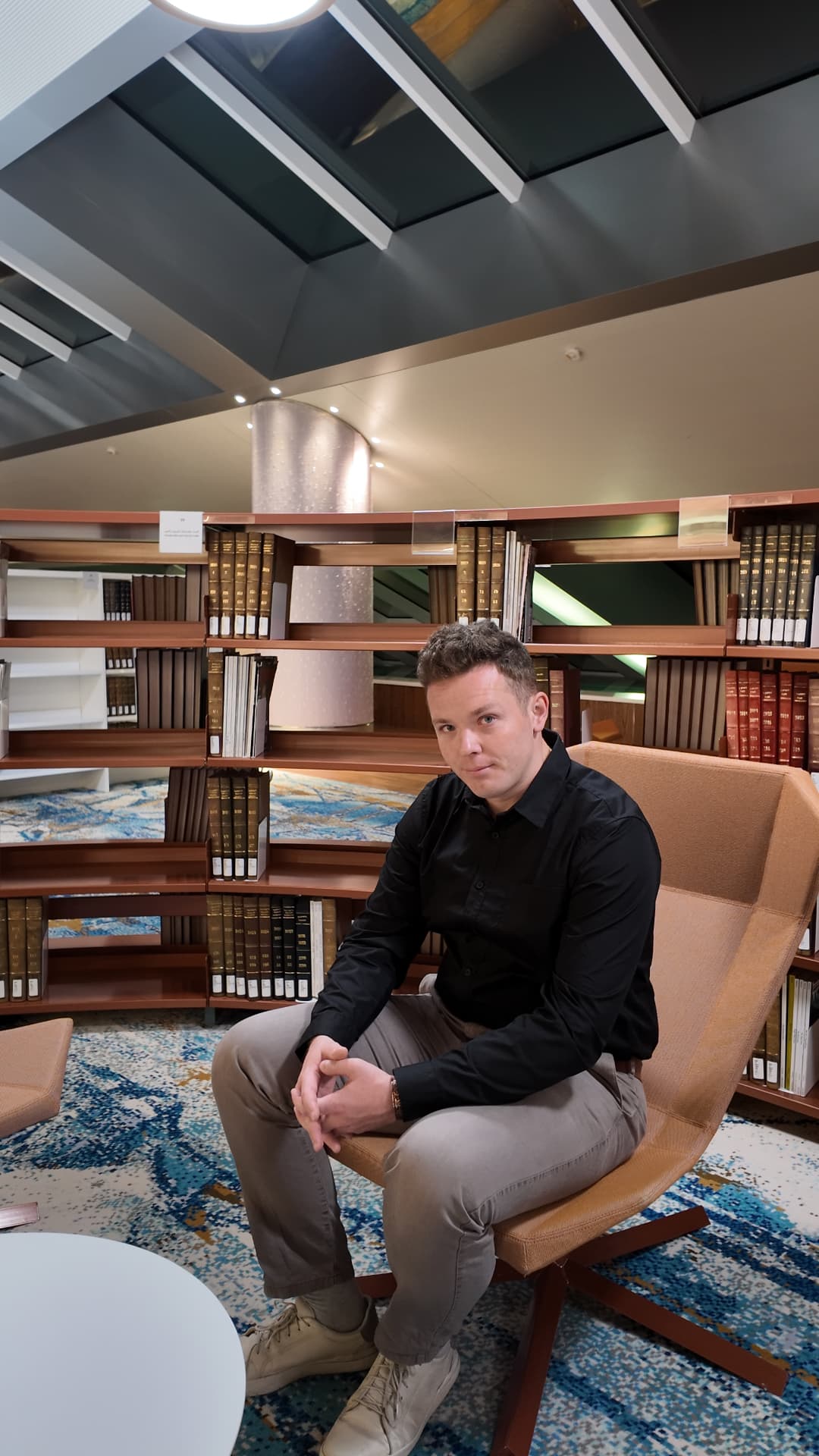 Nikita seated among architecture books in a library